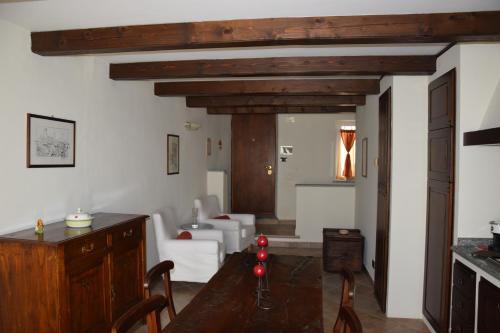 a living room with a wooden table and a living room with a couch at An tij slè - Nel cuore del borgo in Guarene