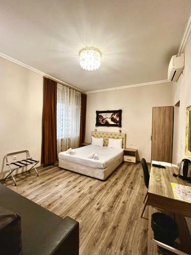a hotel room with a bed and a chandelier at Damyanov House in Kazanlŭk
