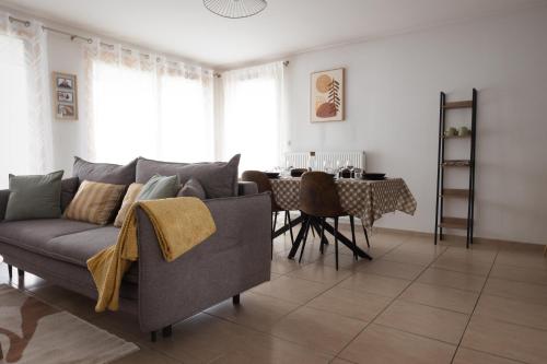 a living room with a couch and a table at Appartement le Joliot Curie 4-6 pers à Lyon - Eurexpo - LDLC - POLUTEC - SALON DE L'AUTO in Lyon