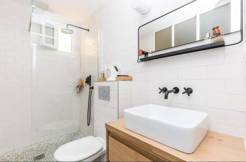 une salle de bain blanche avec un lavabo et des toilettes dans l'établissement Appartement Élégant & Chic à Paris, à Paris