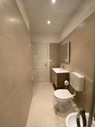 a bathroom with a white toilet and a sink at Giotto 2 Guesthouse in Maserà di Padova