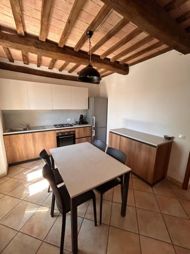 a kitchen with a table and chairs in a room at La casina di Montemerano in Montemerano