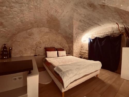 une chambre avec un lit dans une pièce en pierre dans l'établissement Loft design dans hotel particulier, à Montpellier