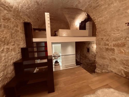 Cette chambre est dotée de lits superposés et d'un mur en pierre. dans l'établissement Loft design dans hotel particulier, à Montpellier