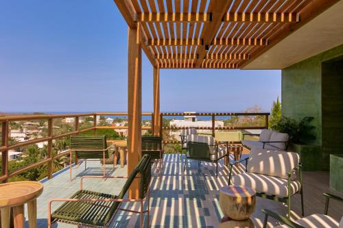 a patio with chairs and tables on a deck at Punta Nayaá - Adults Only in Puerto Escondido