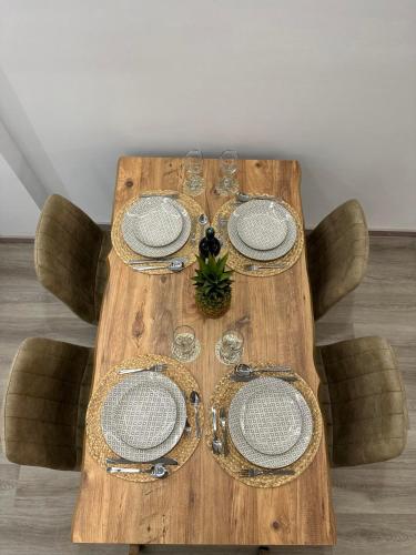 a wooden table with plates and glasses on it at The Heidi's Central House in Kos Town
