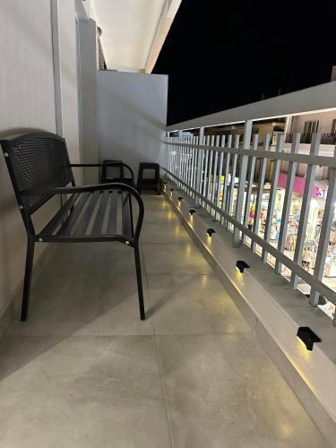 a bench sitting on a balcony with birds on the floor at The Heidi's Central House in Kos Town