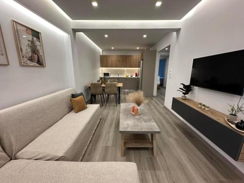 a living room with a couch and a flat screen tv at The Heidi's Central House in Kos Town