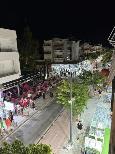 a group of people walking around a city at night at The Heidi's Central House in Kos Town