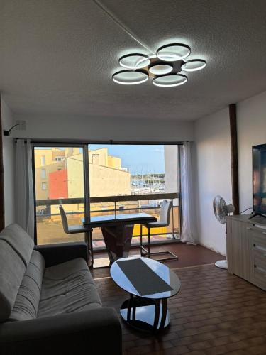 a living room with a couch and a table at Loft en plein centre, Vue port in Cap d'Agde