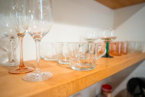 a row of wine glasses sitting on a wooden shelf at Stylish, Artsy Bungalow Central Eastside in Austin