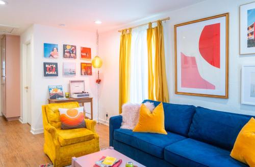 a living room with a blue couch and a yellow chair at Stylish, Artsy Bungalow Central Eastside in Austin