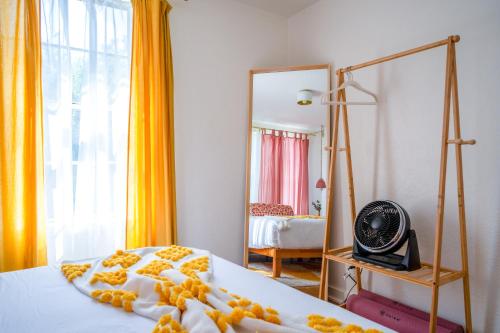 a bedroom with a bed with a mirror and a fan at Stylish, Artsy Bungalow Central Eastside in Austin