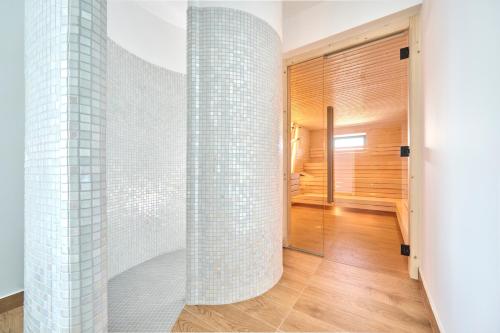 a bathroom with white tiled walls and a walk in shower at Aminess Younique Gaia Green Villas in Njivice