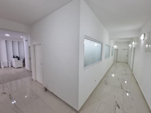 a white hallway with white walls and a mirror at City Square Apartments in Plav
