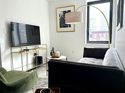 a living room with a couch and a television at Huge Modern 2 bedroom in Little Italy in New York