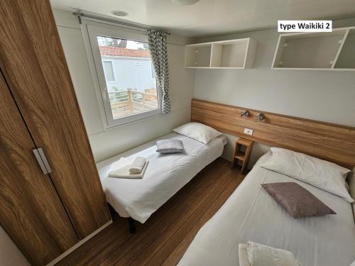 a small room with two beds and a window at Amadria Park Camping Trogir - Mobile Homes 2 in Seget Vranjica