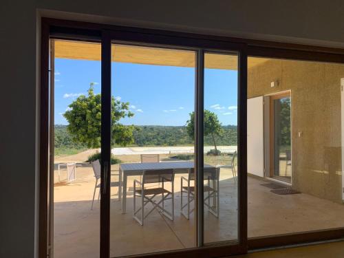 a room with sliding glass doors and a table with chairs at Casa de Mosqueirões in Santa Margarida da Serra