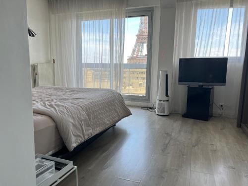 une chambre avec un lit et une télévision à écran plat dans l'établissement Eiffel Tower Incredible View, à Paris