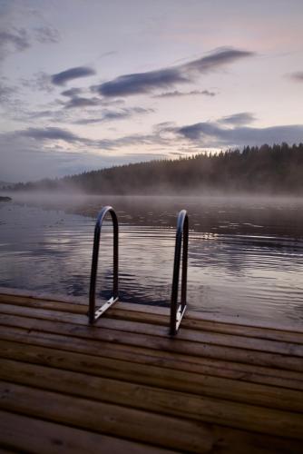 a dock with two metal handles in the water at Luxury off grid house in Viksjöfors