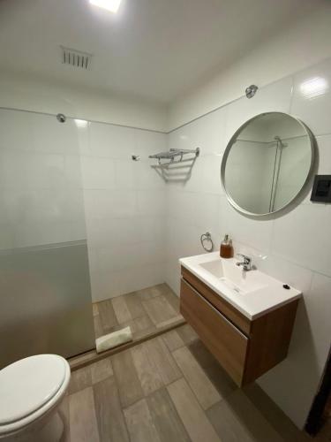 a bathroom with a toilet and a sink and a mirror at El Amanecer in Esquel