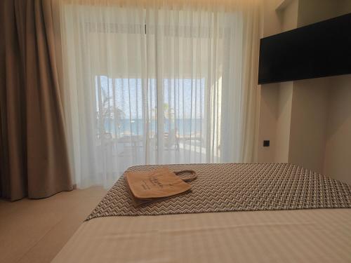 a bed with a tray on it with a window at NISSEA Boutique Hotel in Kardamaina