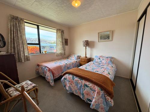 a bedroom with two beds and a window at Home Away From Home in Cromwell
