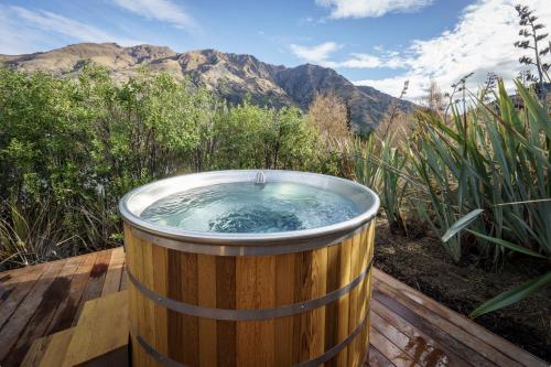 a hot tub in a wooden barrel on a deck at Redfern Retreat in Queenstown