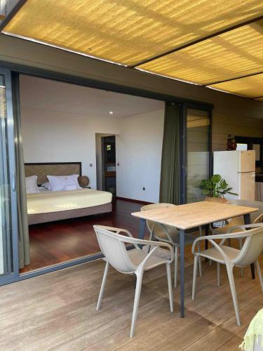 a room with a table and chairs and a bed at Fare O Mape in Faaa