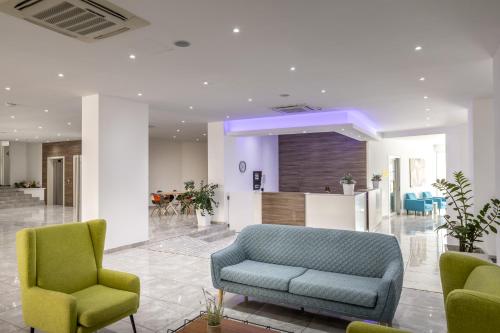 a living room with two chairs and a couch at Papantonia Hotel in Protaras