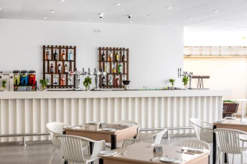 a dining room with tables and white chairs at Papantonia Hotel in Protaras