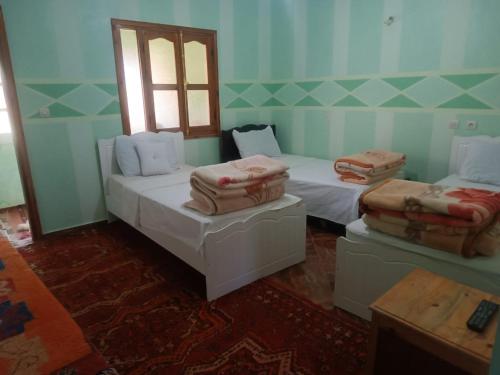 a room with two beds and a window at Ait Ayoub Voyages in Azilal
