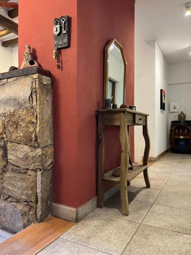 a room with a wooden table and a mirror at La casita en el parque in Chacras de Coria