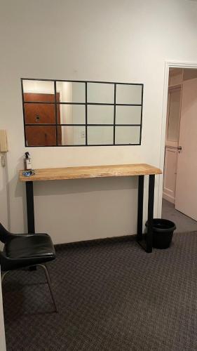 a desk in an office with a mirror on the wall at Hermoso departamento con vista a Obelisco III in Buenos Aires