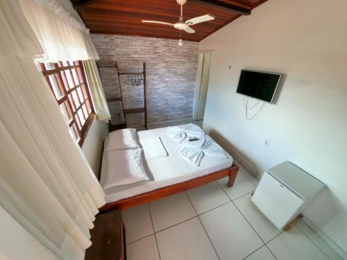 a room with a bed and a television in it at Pousada Praiana Pipa in Pipa