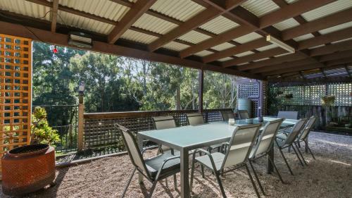 a table and chairs on a patio with a large window at Treetop Retreat - Family Escape with Pool in Metung