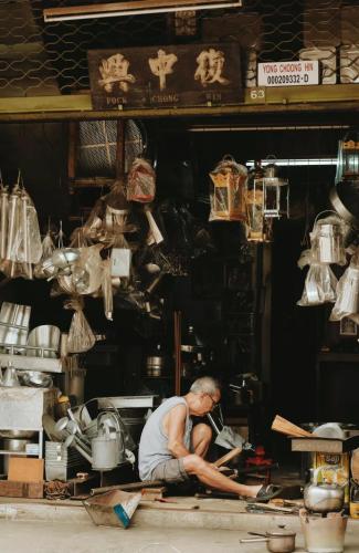 a man is sitting on the floor in a shop at LEJU 79 樂居 Heritage Living in Melaka