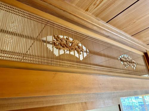 a wooden ceiling with a chandelier on it at EN Guest house in Matsumoto