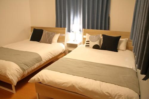 a bedroom with two beds and a window at Liaison House Universal Gateway in Osaka