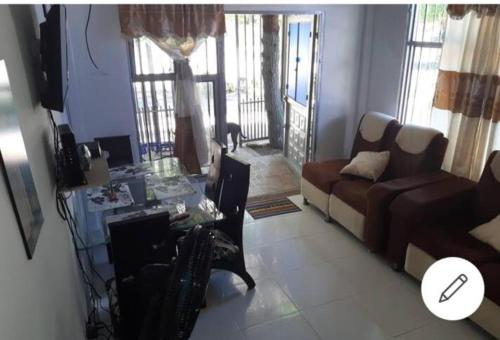 un soggiorno con un divano e un tavolo di vetro di Casa acogedora Girardot 150mts a Girardot