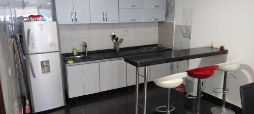 a kitchen with white cabinets and a white refrigerator at Apartamento Coveñas Castillo Club Cabaña 5 in Coveñas