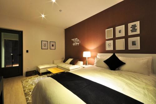 a bedroom with a large bed and a chair at Gout Stay in Daegu