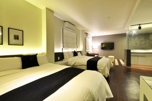 a hotel room with two beds and a bathroom at Gout Stay in Daegu