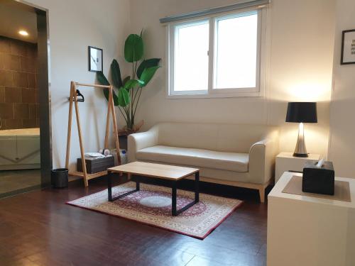 a living room with a couch and a coffee table at Gout Stay in Daegu