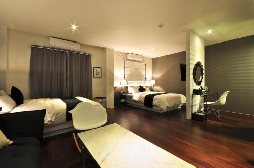 a hotel room with two beds and a couch at Gout Stay in Daegu