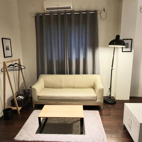 a living room with a white couch and a table at Gout Stay in Daegu