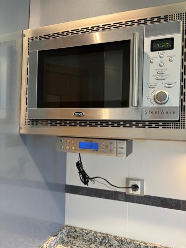 a microwave oven on a wall in a kitchen at Apartamento Oviedo Naranco in Oviedo