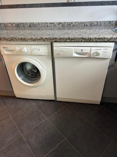 a washer and dryer under a counter in a kitchen at Apartamento Oviedo Naranco in Oviedo