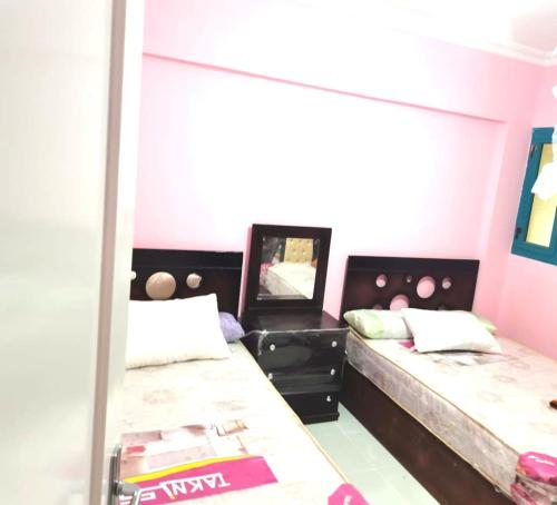 a bedroom with two beds and a mirror at منتجع ريفيرا in Ras Sedr