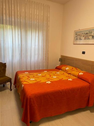 a bedroom with two beds with orange sheets and a window at A casa di Bia in Castro dei Volsci